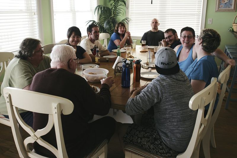 Friends and family sharing a meal at a long table
